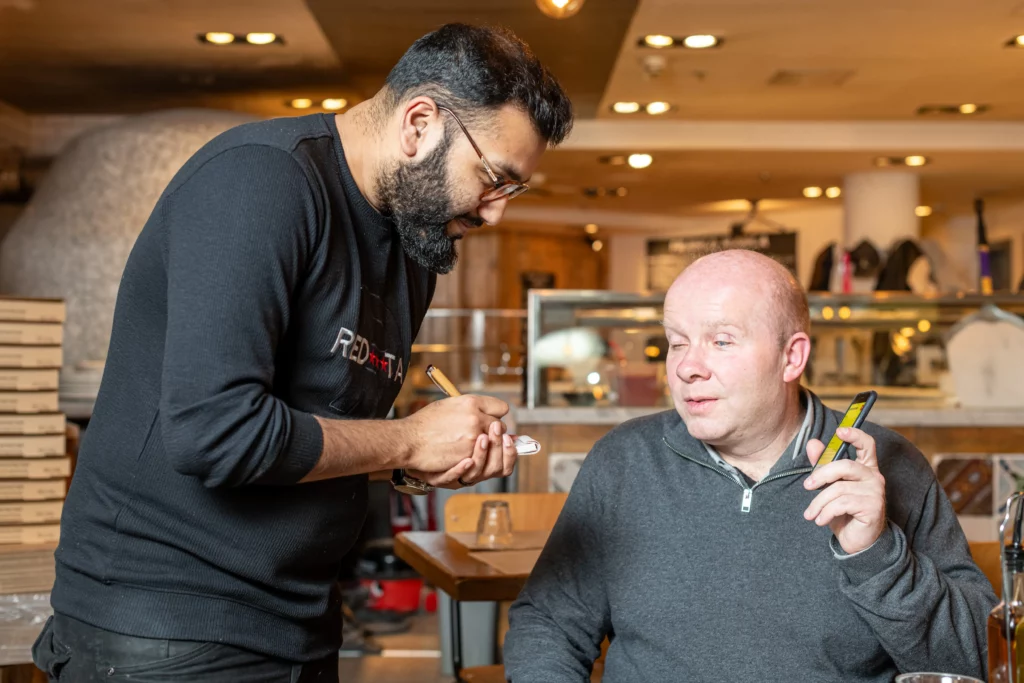a waiter talking to Matt Wadsworth creator of Good Food Talks