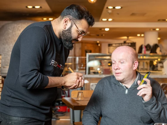 a waiter talking to Matt Wadsworth creator of Good Food Talks