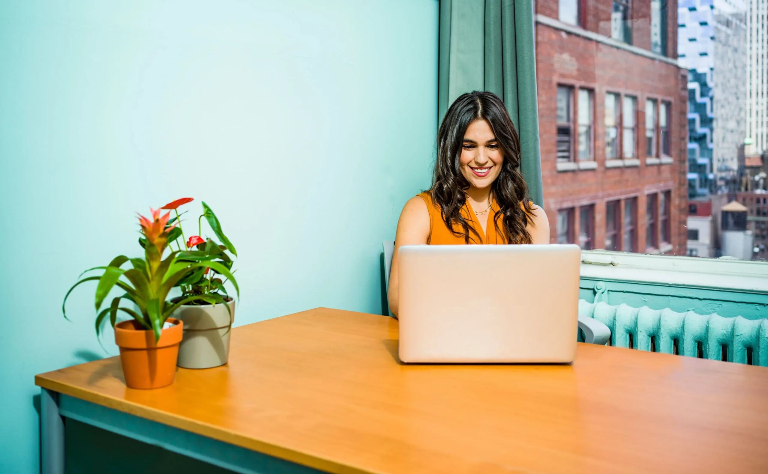 woman smiling while on laptop computer