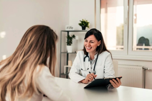 woman smiling with patient wearing doctor whites