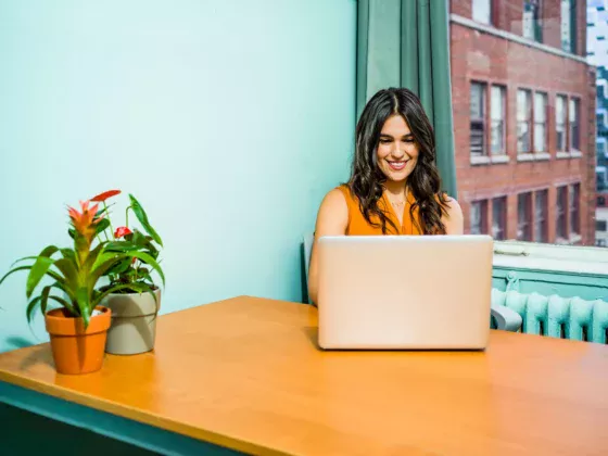 woman smiling while on laptop computer